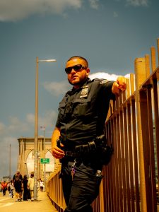 A man in a police uniform standing on a bridge