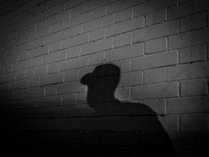 silhouette of man leaning on wall