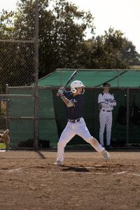 A baseball player is getting ready to swing.