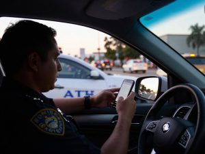 Police officer checking warrant database during traffic stop in Los Angeles