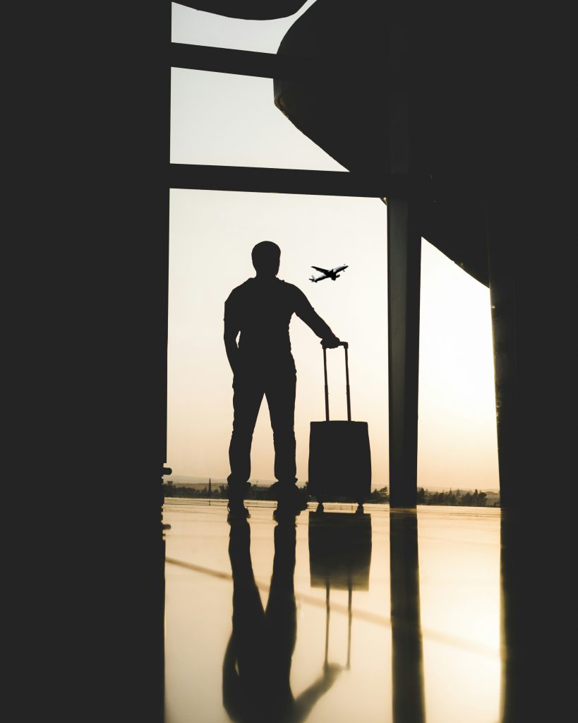 silhouette of man holding luggage inside airport silhouette of man holding luggage inside airport