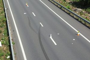 Skid marks and debris at car crash site on highway
